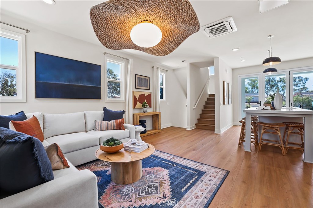 19071 Main Street, Unit 105 Huntington Beach, CA 92648 - Photo 5 of 18 a living room with furniture and a wooden floor