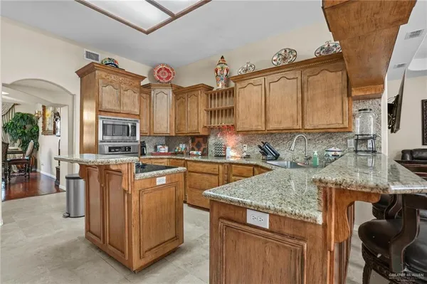 a kitchen with stainless steel appliances granite countertop a sink a stove and a microwave