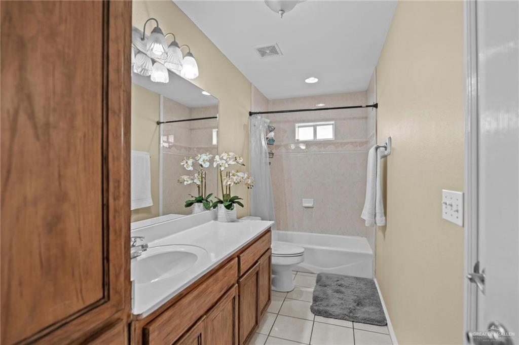 2809 Santa Laura Street Mission, TX 78572 - Photo 32 of 41 a bathroom with a granite countertop sink a toilet and shower