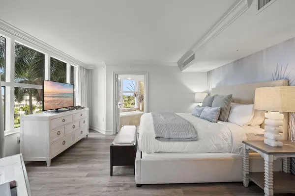 a spacious bedroom with a large bed and a flat tv screen on dresser