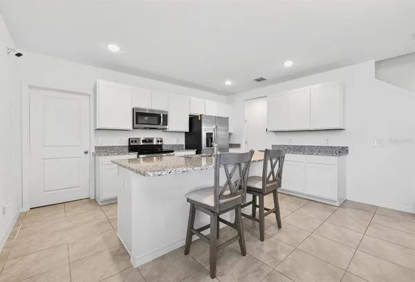 a kitchen with a refrigerator and a stove top oven