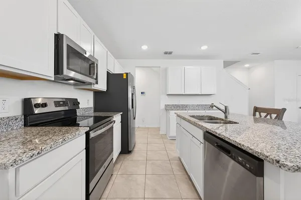 a kitchen with stainless steel appliances granite countertop a sink stove and microwave