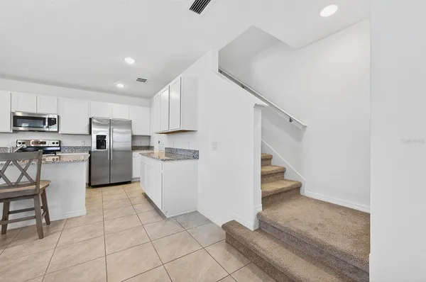 a view of kitchen with furniture and refrigerator