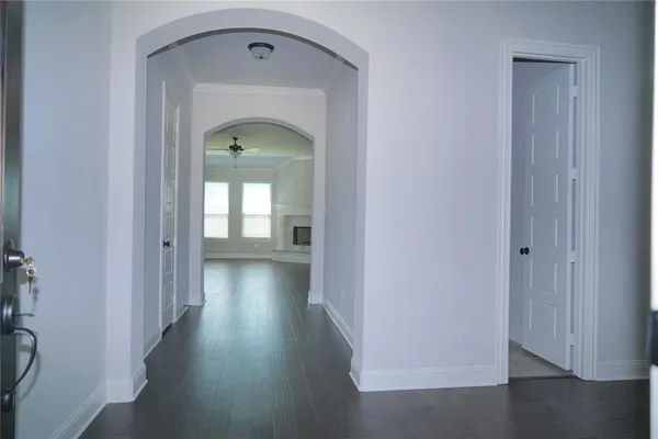 a view of a hallway with wooden floor and a door