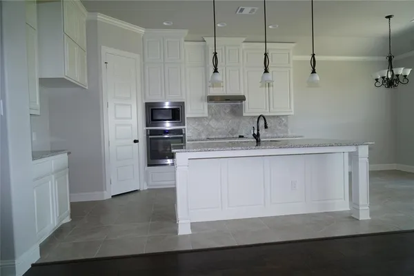 a kitchen with stainless steel appliances granite countertop a sink a stove and a refrigerator
