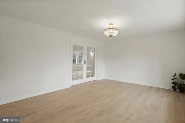 an empty room with a painting and a window