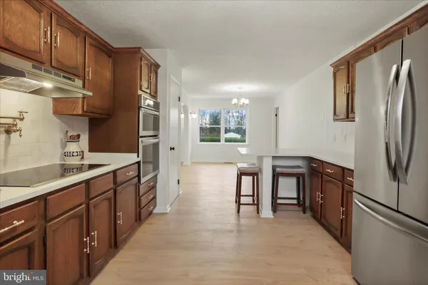 an empty room with fireplace cabinet and windows