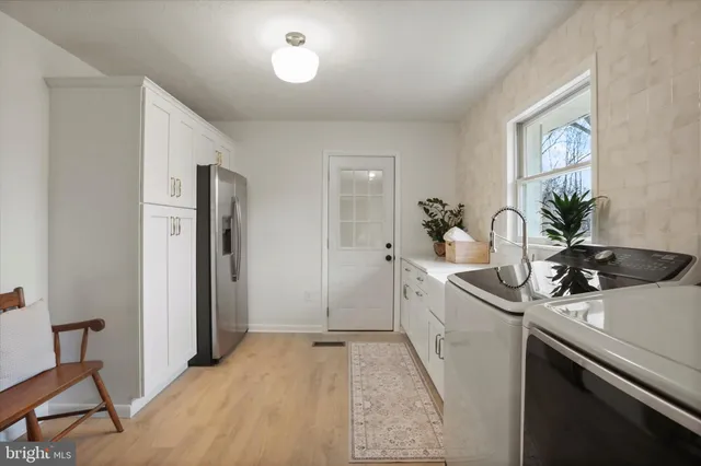 a kitchen with stainless steel appliances a table chairs refrigerator and a sink