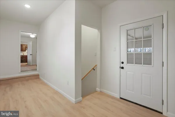 a kitchen with a sink dishwasher and white cabinets with wooden floor