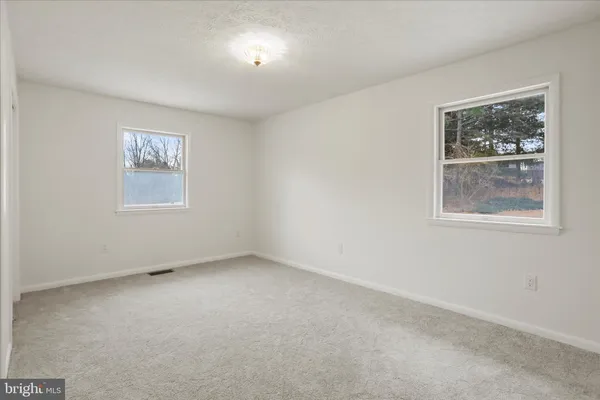 an empty room with a ceiling fan and a window