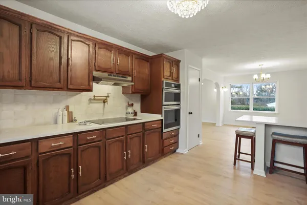 a kitchen with stainless steel appliances granite countertop a refrigerator and a stove top oven