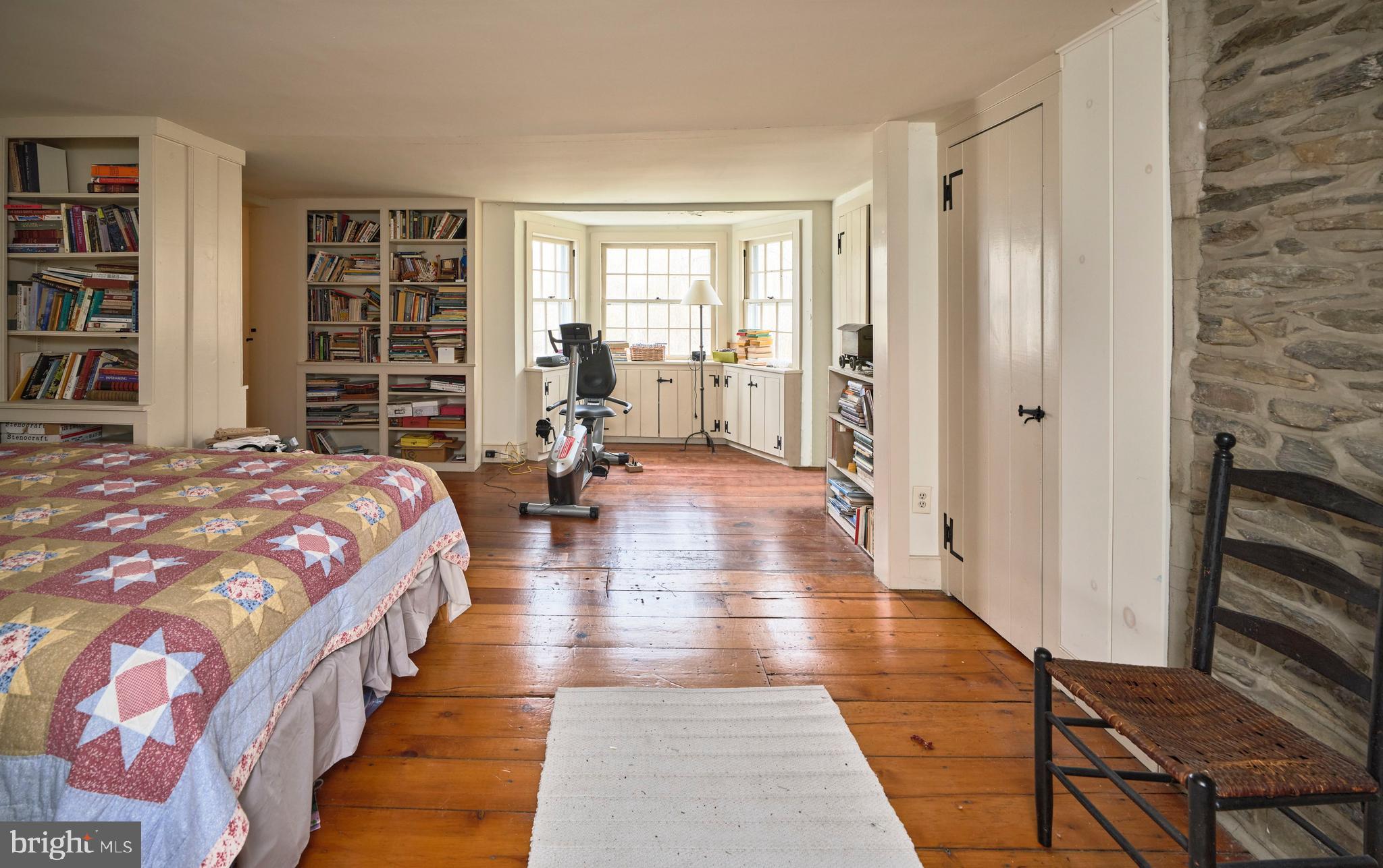 3837 Curly Hill Road Doylestown, PA 18902 - Photo 19 of 42 a spacious bedroom with a bed and a book shelf