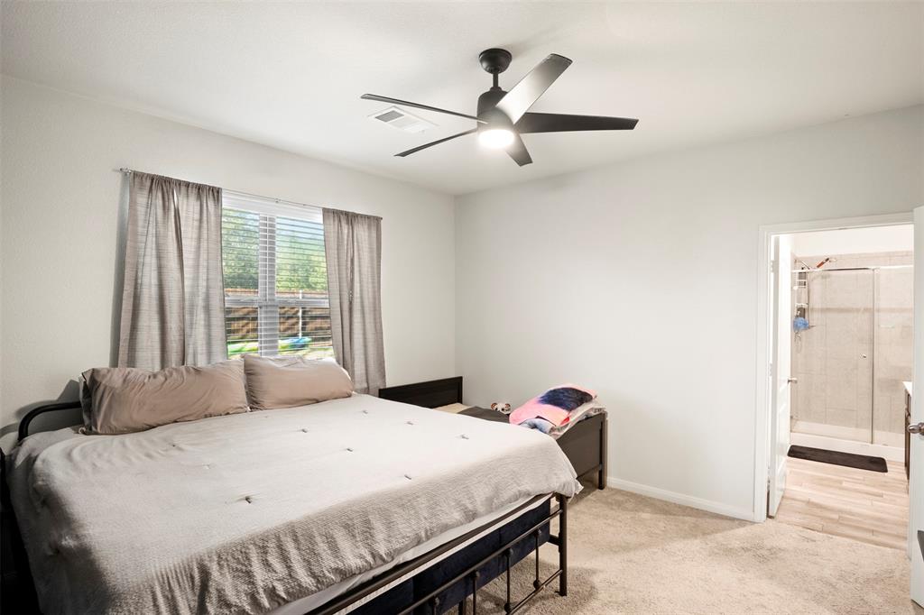 105 Patton Lane Venus, TX 76084 - Photo 15 of 29 Bedroom featuring light carpet, a ceiling fan, and ensuite bath