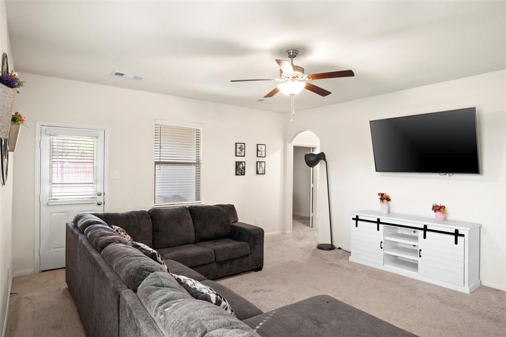 105 Patton Lane Venus, TX 76084 - Photo 8 of 29 Living room with light colored carpet, arched walkways, and a ceiling fan