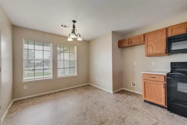 a view of a kitchen with an empty room and a window
