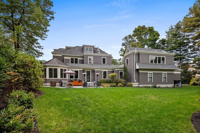 a view of a house with a big yard and large trees