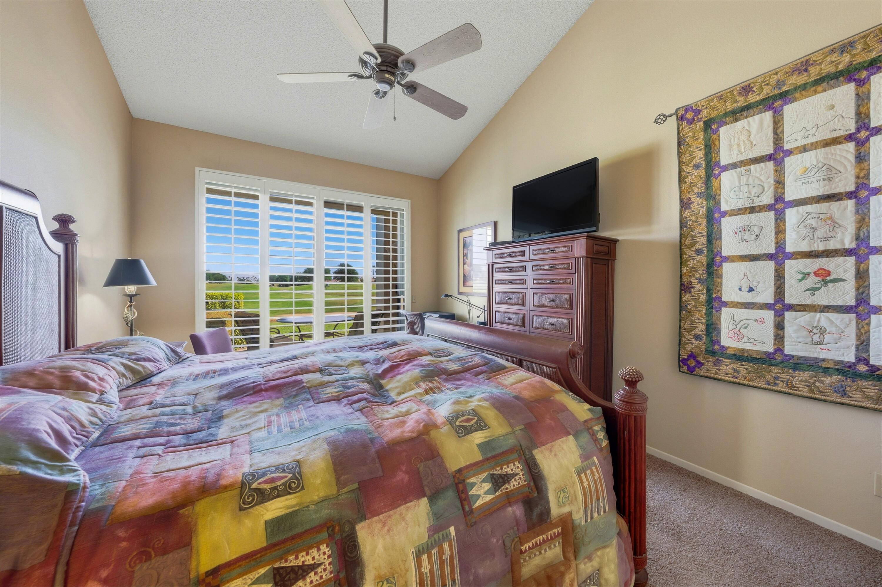 54860 Inverness Way La Quinta, CA 92253 - Photo 15 of 26 a bedroom with a bed a flat screen tv and a window