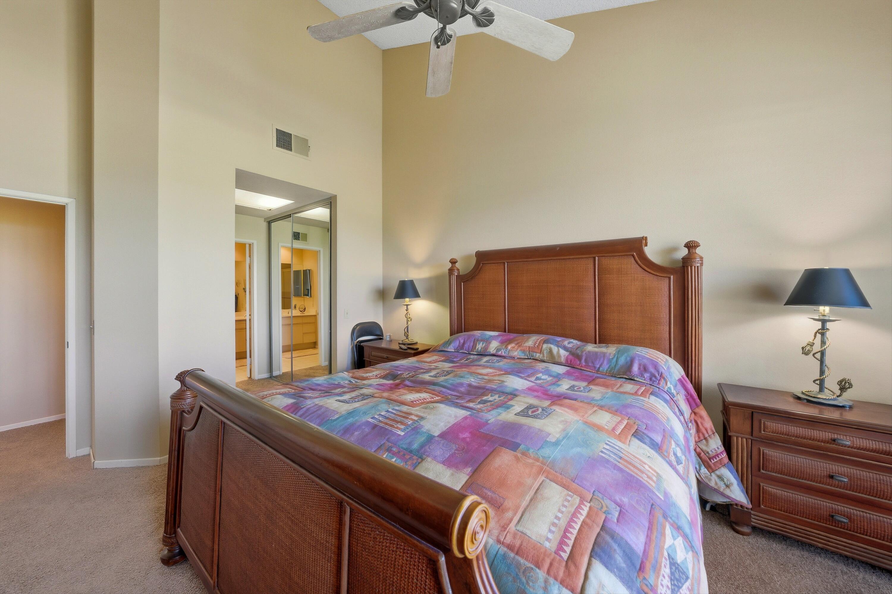 54860 Inverness Way La Quinta, CA 92253 - Photo 16 of 26 a bedroom with a bed and a chandelier