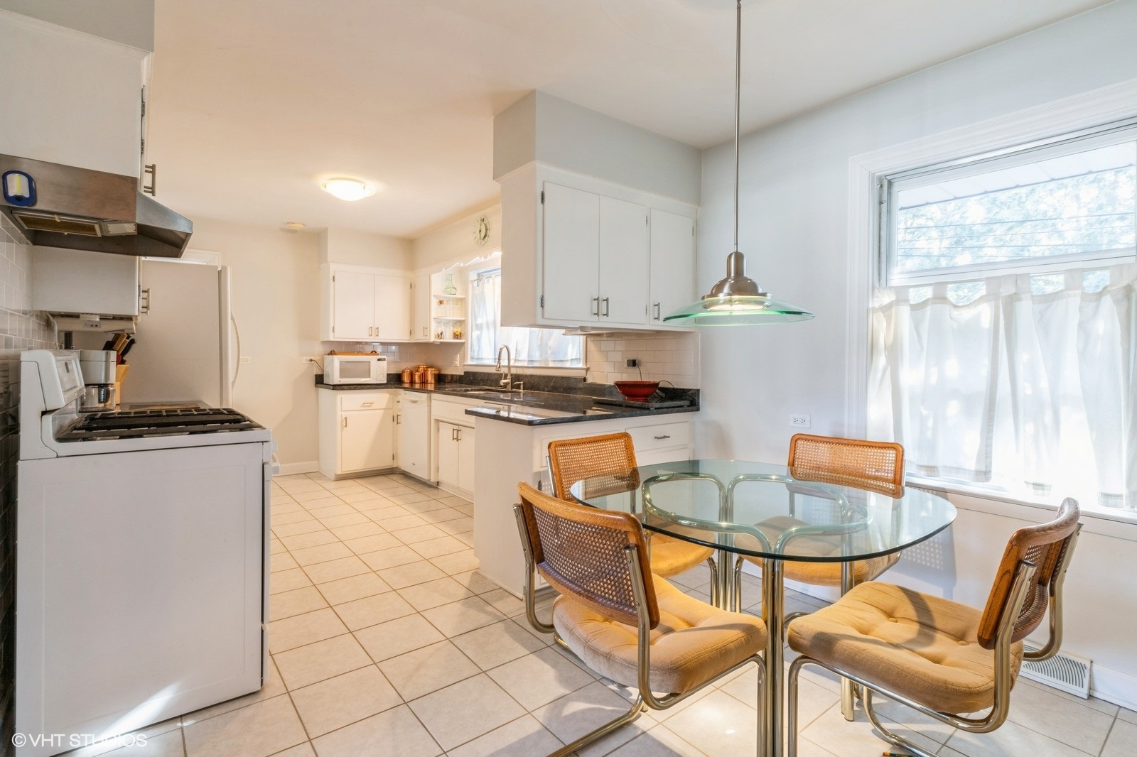 546 North Dee Road Park Ridge, IL 60068 - Photo 6 of 18 a kitchen with stainless steel appliances granite countertop a stove a refrigerator a sink a dining table and chairs with white cabinets