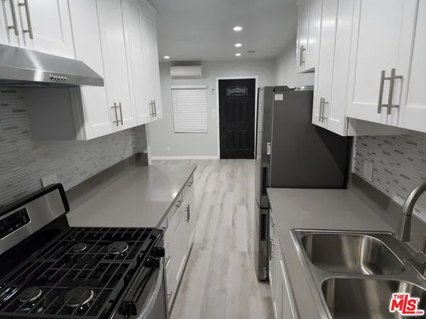 a kitchen with granite countertop a stove and a refrigerator