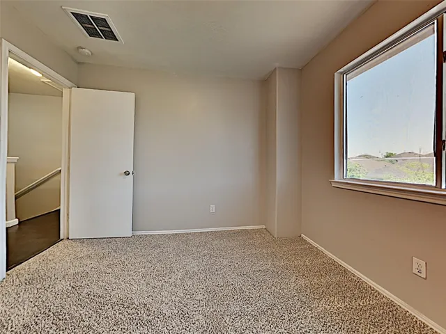 a view of an empty room with window and closet