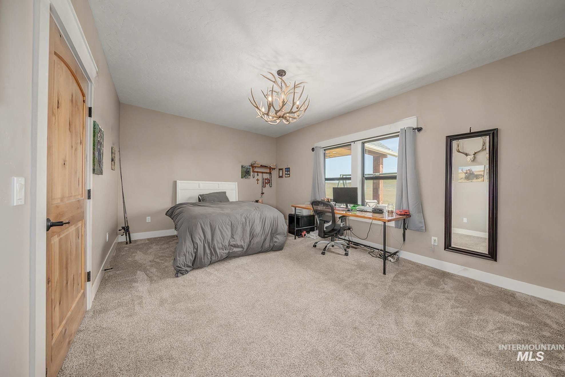 10228 Payette Heights Road Payette, ID 83661 - Photo 27 of 50 Spacious room featuring vaulted ceilings, light-tone carpeting, and a natural wood-finish door