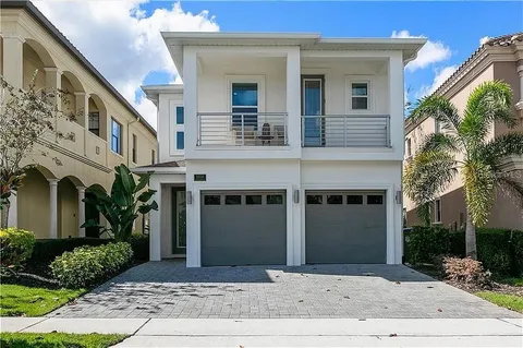 a front view of a house with a yard and potted plants