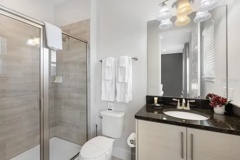 a bathroom with a granite countertop sink toilet and shower