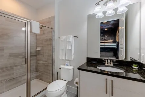 a bathroom with a granite countertop sink a toilet and shower