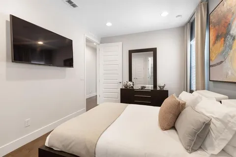 a bedroom with a large bed and a flat screen tv