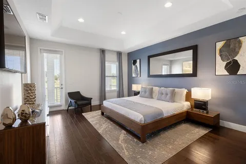a spacious bedroom with a bed and wooden floor