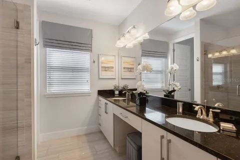 a bathroom with double vanity and a mirror