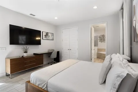 a bedroom with a bed and a flat screen tv