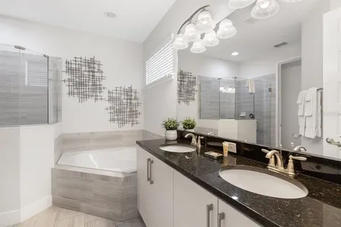a bathroom with a granite countertop double vanity and a mirror