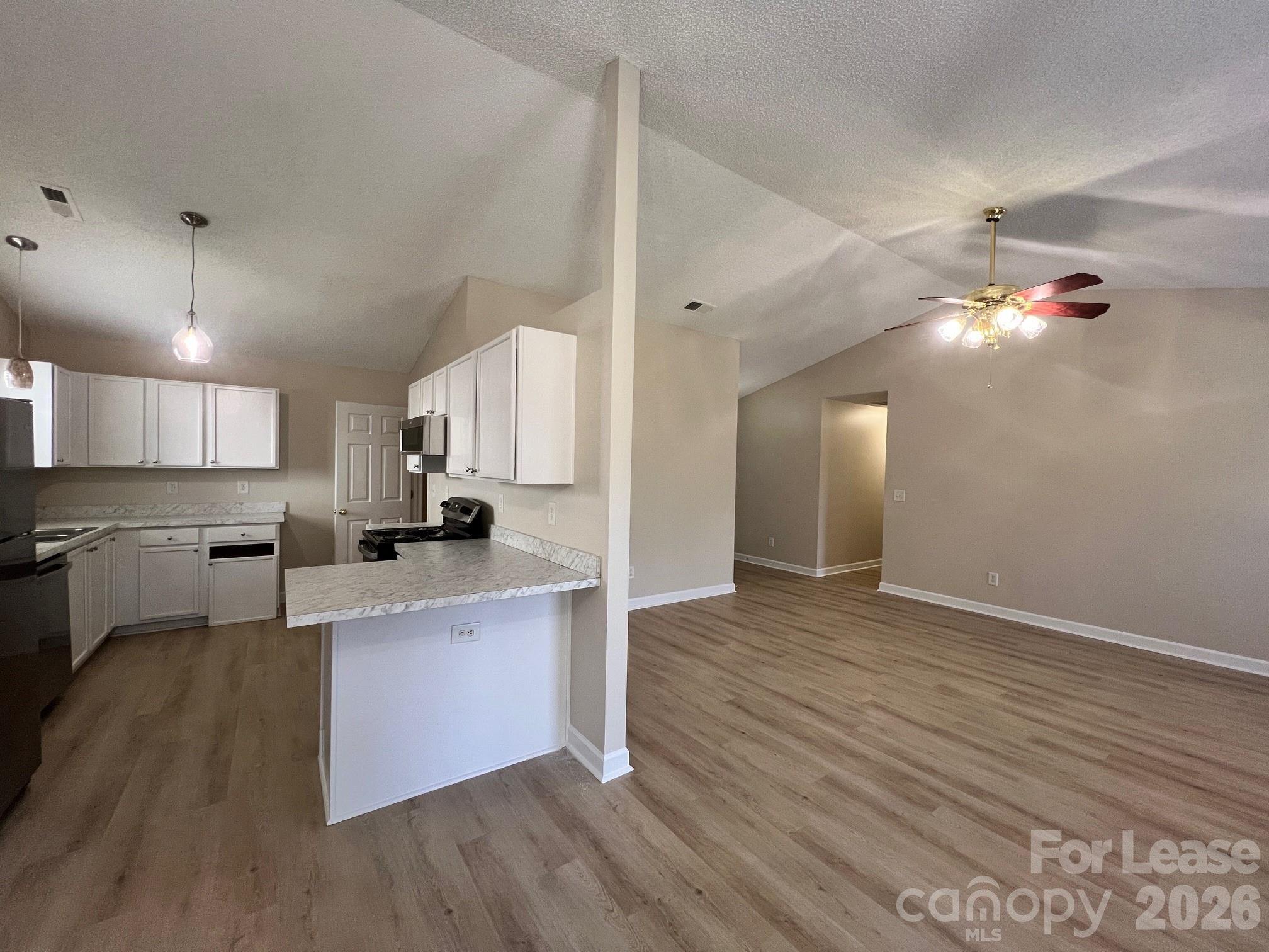 2616 Captains Watch Road Northeast Kannapolis, NC 28083 - Photo 7 of 25 a large kitchen with cabinets wooden floor and stainless steel appliances