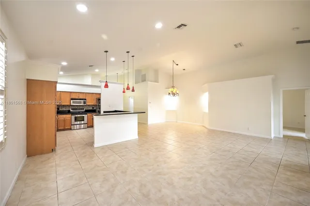 a kitchen with stainless steel appliances granite countertop a sink and a refrigerator