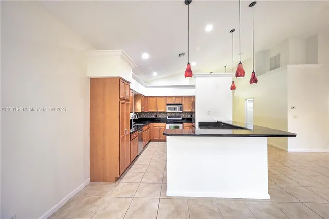 a kitchen with stainless steel appliances granite countertop a refrigerator and a sink