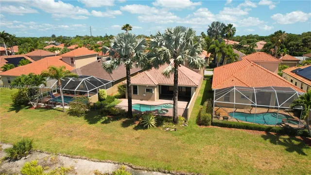 an aerial view of a house with swimming pool and sitting area