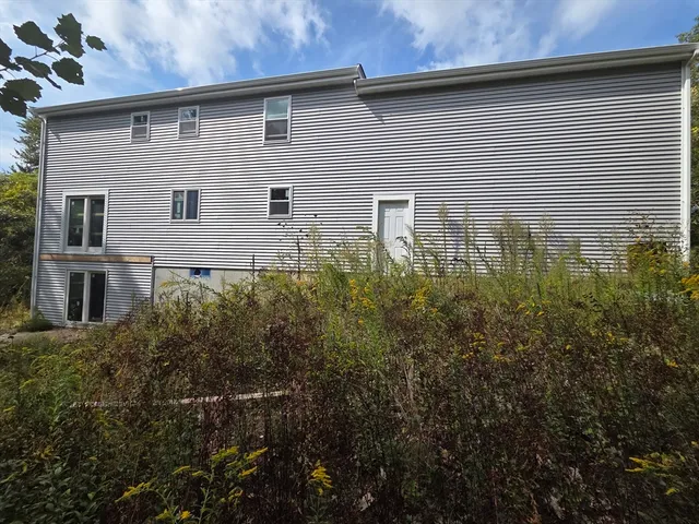a front view of a house with plants