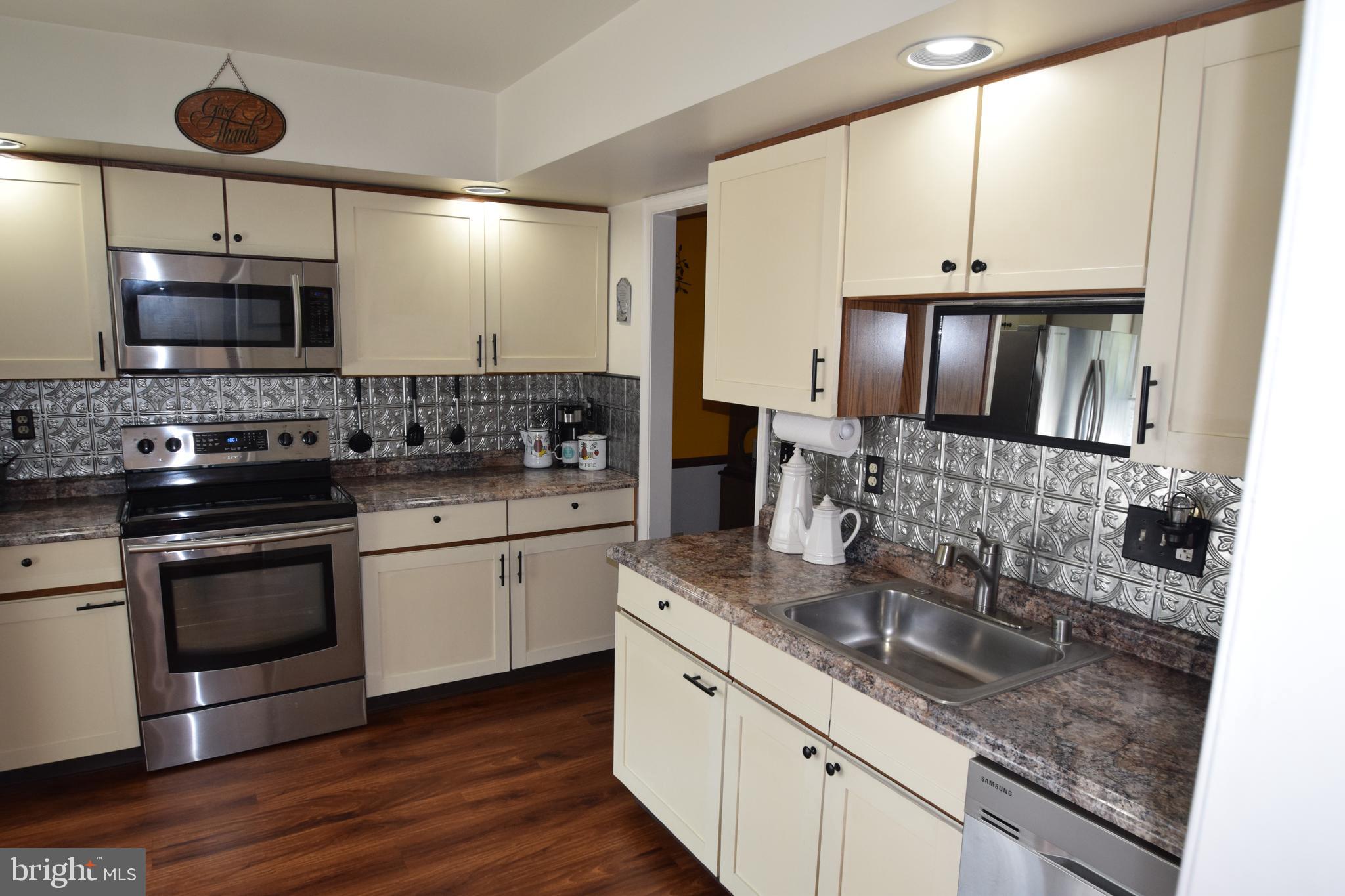 129 Woodhill Road Wilmington, DE 19809 - Photo 4 of 25 a kitchen with stainless steel appliances granite countertop a sink stove and microwave