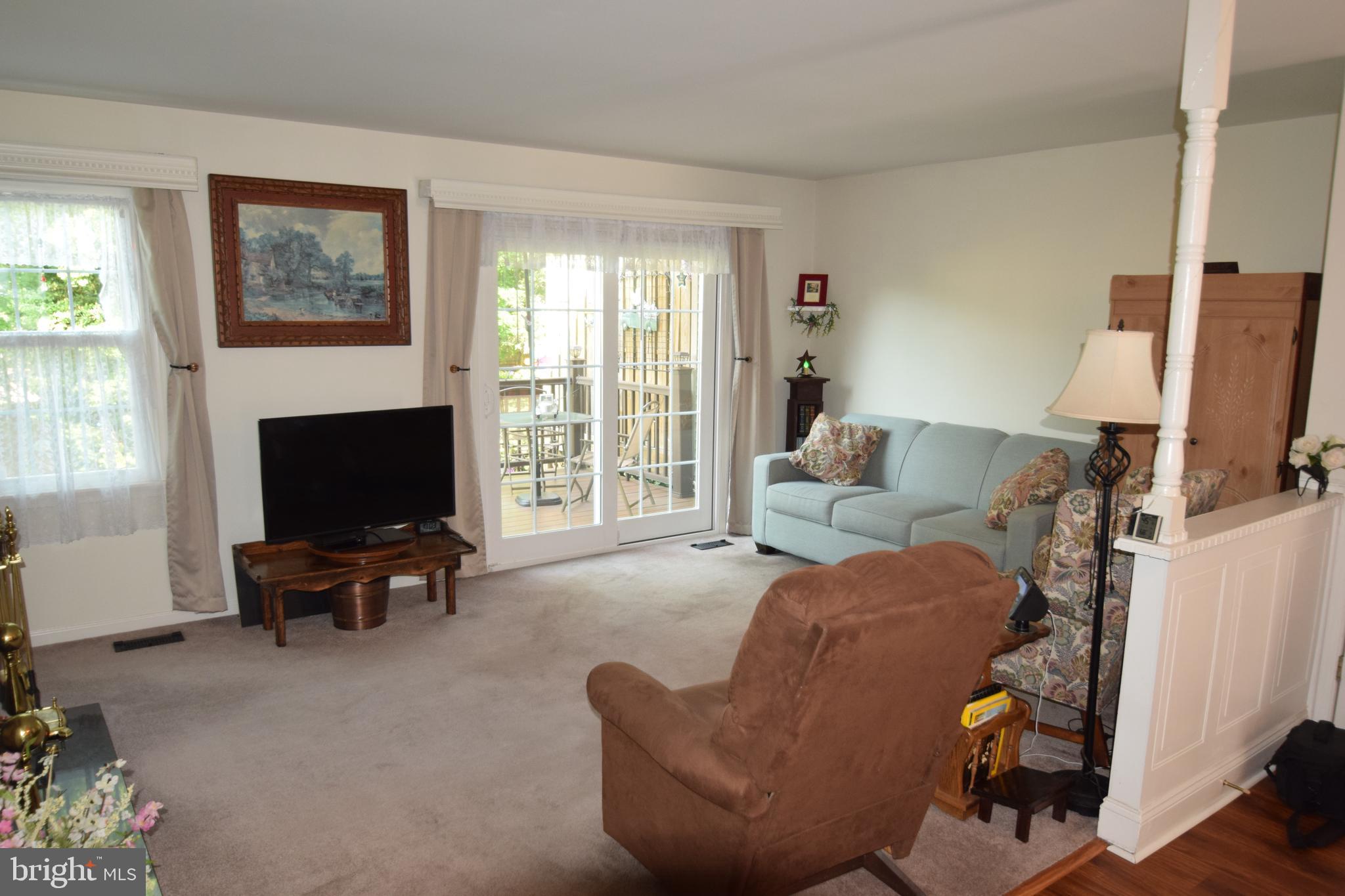 129 Woodhill Road Wilmington, DE 19809 - Photo 9 of 25 a living room with furniture floor to ceiling window and a flat screen tv