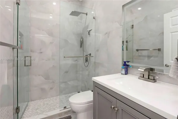 a bathroom with a sink a toilet and shower
