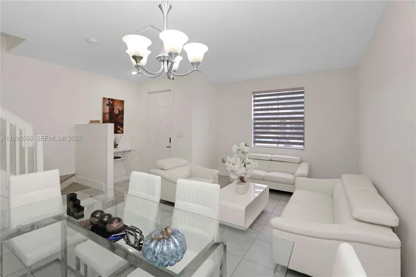 a living room with furniture a chandelier and a table