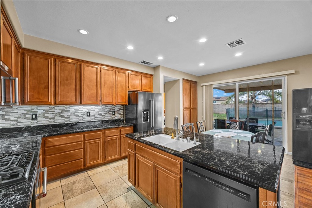 150 Saddleback Way Perris, CA 92570 - Photo 14 of 46 a kitchen with stainless steel appliances granite countertop sink stove and cabinets