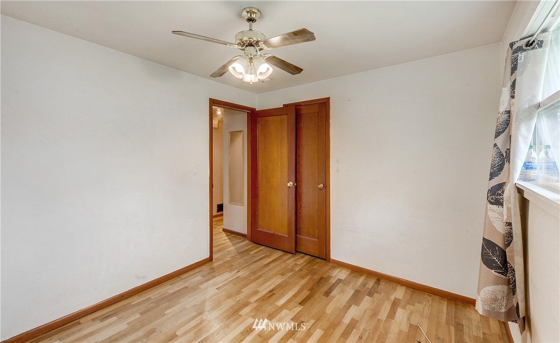 366 Earlington Avenue Southwest Renton, WA 98057 - Photo 20 of 33 an empty room with wooden floor and a ceiling fan