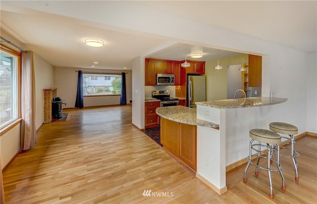 366 Earlington Avenue Southwest Renton, WA 98057 - Photo 5 of 33 a large kitchen with kitchen island a counter top space a sink a stove and wooden floor