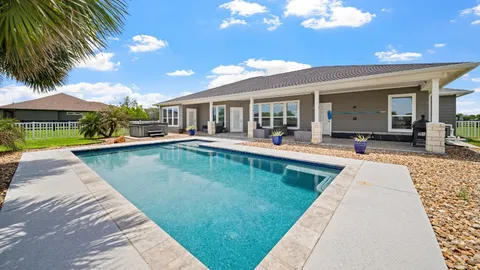 a view of a house with swimming pool and porch with furniture