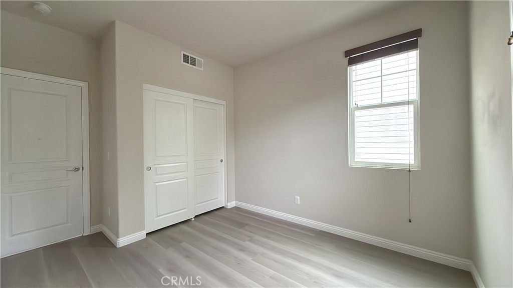 7833 Wild Rye Street Chino, CA 91708 - Photo 23 of 44 an empty room with wooden floor and windows