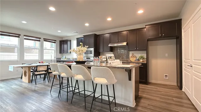 a kitchen with granite countertop stainless steel appliances a sink stove and refrigerator