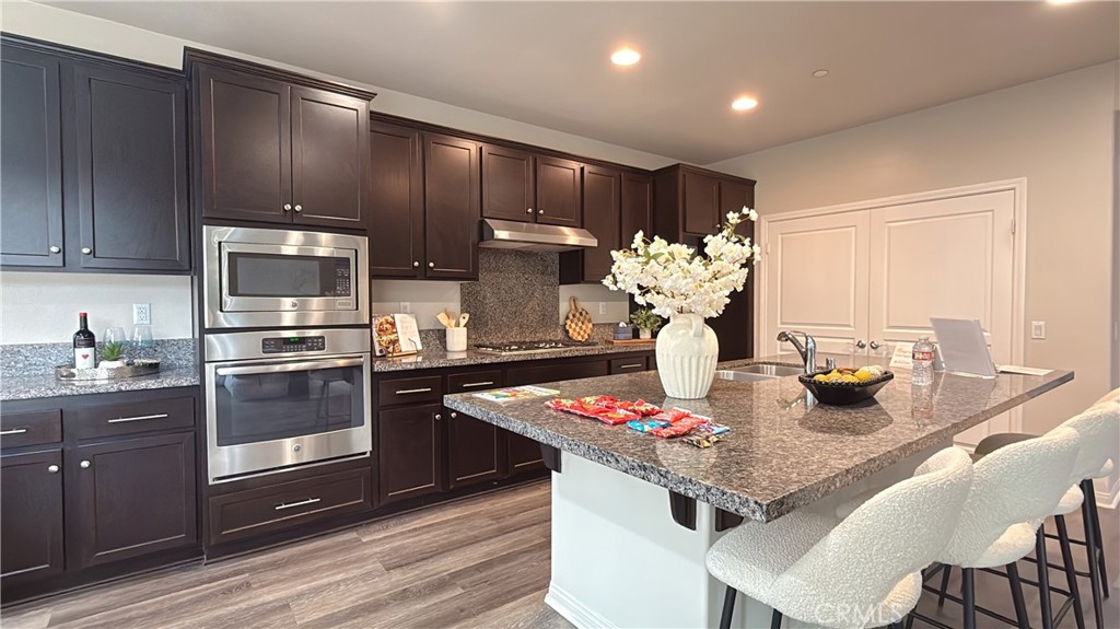 7833 Wild Rye Street Chino, CA 91708 - Photo 4 of 44 a kitchen with granite countertop stainless steel appliances a sink stove and refrigerator